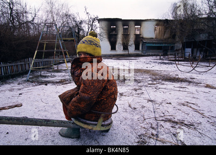 First Chechen War, 8 year old, Olla, sitting in the playground of her bombed out school South of Grozny in Chechnya. Stock Photo