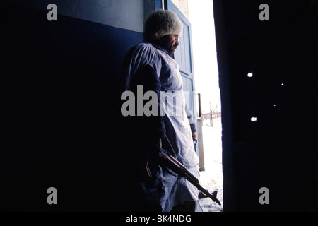 First Chechen War, Armed Chechen fighter looks out the door of an apartment building South of Grozny in Chechnya. Stock Photo