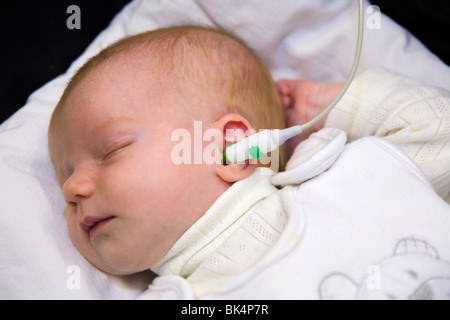 Newborn / new born baby undergoes a routine neonatal hearing screening test – Automated otoacoustic emissions test. Stock Photo