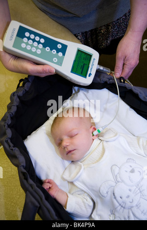 Newborn / new born baby undergoes a neonatal hearing screening test: Automated otoacoustic emissions test. Stock Photo