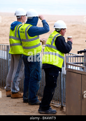 Three workmen having a coffee, Watergate Bay, Cornwall Stock Photo