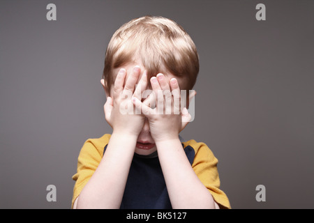 Boy Covering Face Stock Photo