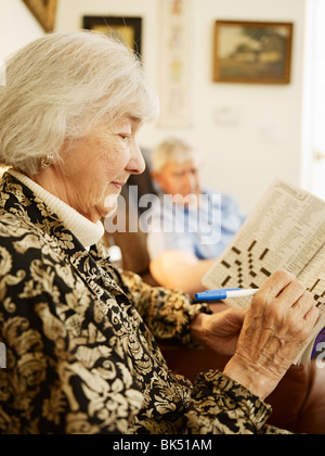 Elderly Couple in Retirement Home, Woman Working on Crossword Puzzle Stock Photo