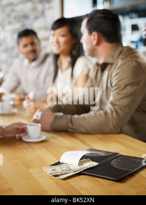 Friends at Restaurant Paying Bill Stock Photo