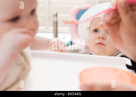 Boy Watching another Child being Fed Stock Photo