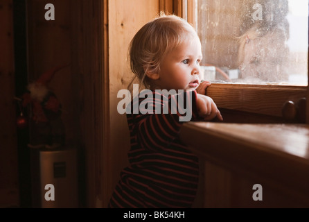 Portrait of Girl Looking out of Window Stock Photo