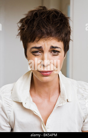Adult 40-year-old Latina woman ruffles her hair desperate with anxiety ...