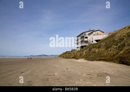 A beach house sits on sand dunes eroded by high water and wind on the Oregon Pacific Coast in Newport, Oregon Stock Photo