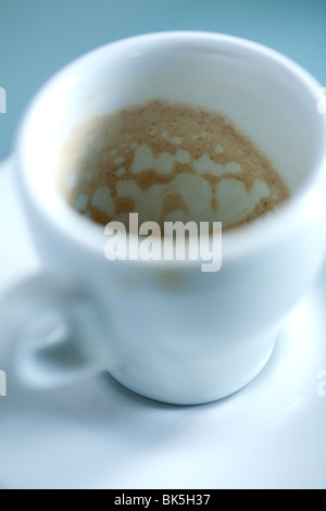 An empty white espresso cup and saucer with the stain of coffee inside the cup Stock Photo
