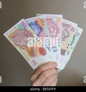 Hands holding and exchanging south african rand banknotes against a ...