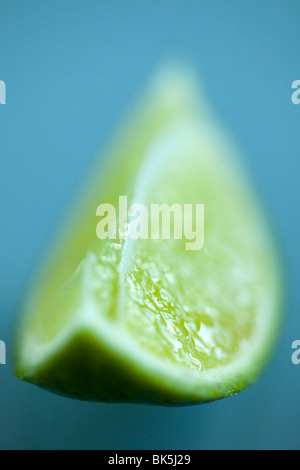 A fresh slice of lime with selective focus on a clean glass surface with copyspace Stock Photo