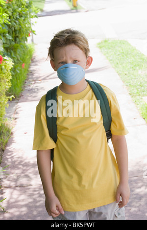 Little Boy Walking to School Wearing a Face Mask Stock Photo