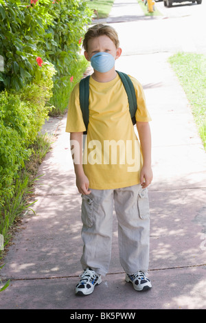 Little Boy Walking to School Wearing a Face Mask Stock Photo