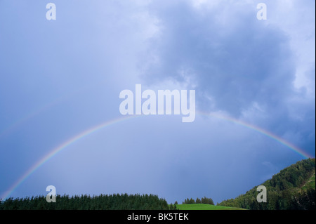 Rainbow over Field and Trees, Salzburg, Austria Stock Photo