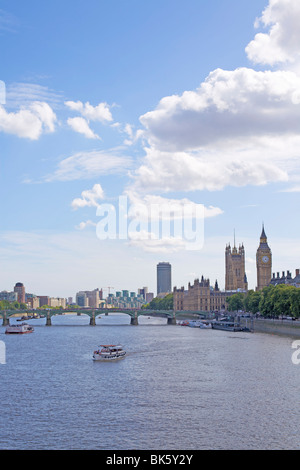 Tourist cruise boat on the River Thames and the Houses of Parliament in the distance, London, England, United Kingdom, Europe Stock Photo
