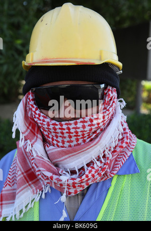 Construction worker wearing protective clothing, helmet and sunglasses in Doha, Qatar, Middle East Stock Photo