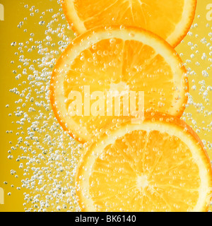 Fresh orange dropped into water with bubbles Stock Photo