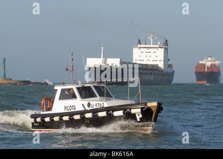 cargo ships manoeuvring in the port of Livorno (Italy), pilot boat Stock Photo