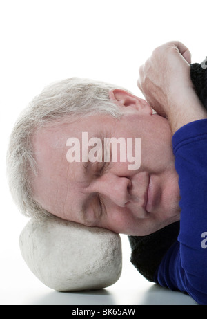 Man who sleeps deeply and smoothly on a stone. Concept for someone who is treated with medication that is very good Stock Photo