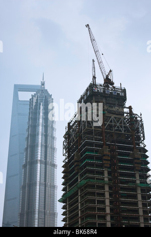 Skyscraper under construction in Shanghai against a blue sky and an ...