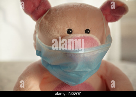 Toy pig with flu mask, head shot. Stock Photo