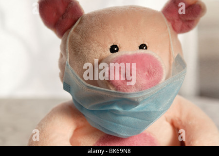 Toy pig with flu mask, head shot. Stock Photo