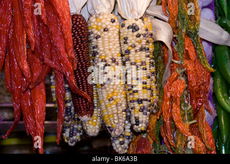 Bunch of hot red and green chili, peppers and colorful corn-cobs in a spanish market, Travel Barcelona, Spain Stock Photo