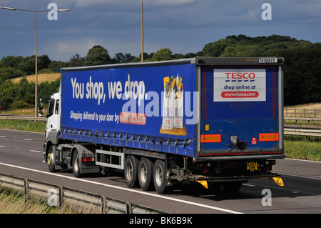 Side view hgv supermarket food supply chain store grocery delivery lorry truck with trailer advertising Tesco food business driving on UK motorway Stock Photo
