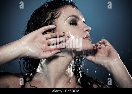 Water flowing on woman face. Contrast colors. Stock Photo