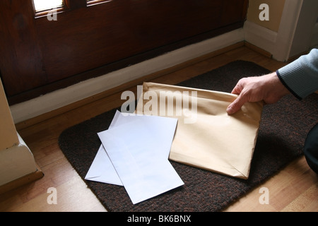 Picking Up Envelopes from a Door Mat MODEL & PROPERTY RELEASED Stock Photo