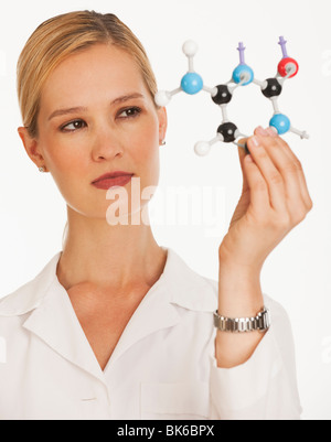 female chemist holding up molecules and looking at them Stock Photo