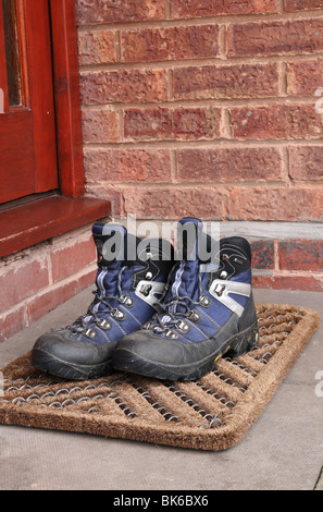 Walking Boots on a Front Door Mat Stock Photo