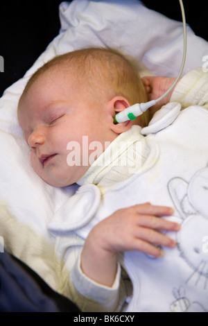 Newborn / new born baby undergoes a neonatal hearing screening test: Automated otoacoustic emissions test. Stock Photo