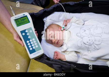 Newborn / new born baby undergoes a neonatal hearing screening test: Automated otoacoustic emissions test. Stock Photo