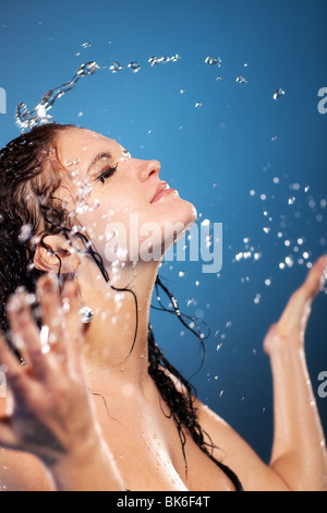 Young woman washing face. On blue background. Stock Photo