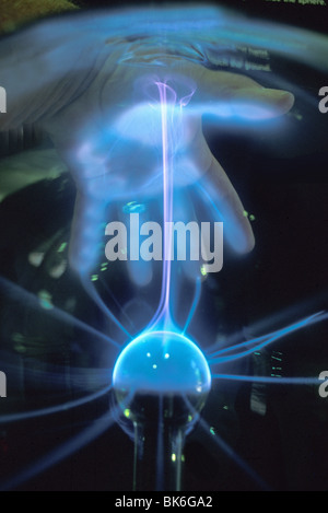 hand creating static electricity arc in plasma ball Duke Power Energy Exploratorium Hunterville North Carolina Stock Photo