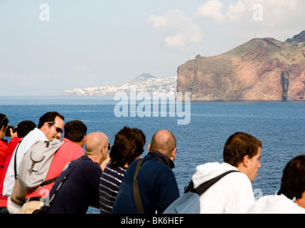 Passengers on board the car ferry that operates between Madeira and the Portuguese mainland admire the island's coastal views. Stock Photo