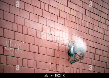 Steam rising from a gas central heating vent in the wall of a building. Stock Photo