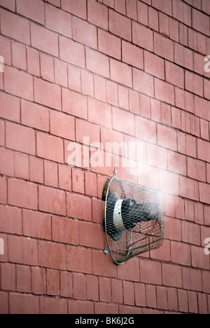 Steam rising from a gas central heating vent in the wall of a building. Stock Photo