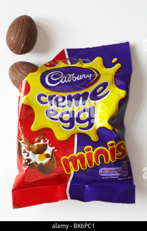 Bag of Cadbury minis creme egg opened with eggs coming out contents spilled spilt isolated on white background  - ready for Easter Stock Photo