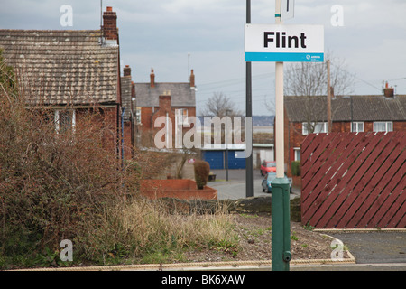 Flint railway sign with Castle Ward housing estate in background Stock Photo