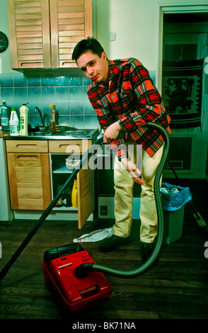 Paris, France, French Male Teen Doing Housework at Home, Not Very Happy. precarious work, paris kitchen apartment Stock Photo