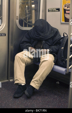 Man sleeps on a New York City subway train. Stock Photo
