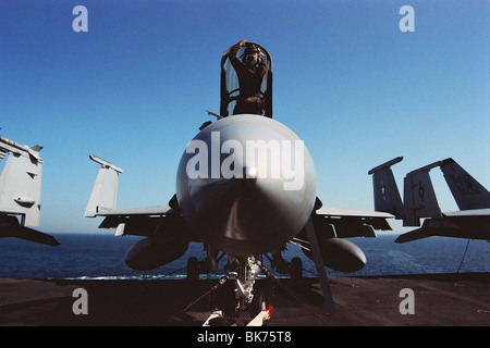 A naval pilot cleans and services an F-18A Hornet aboard the aircraft carrier USS Nimitz in the Persian Gulf, during the 2003 Iraq War. Stock Photo