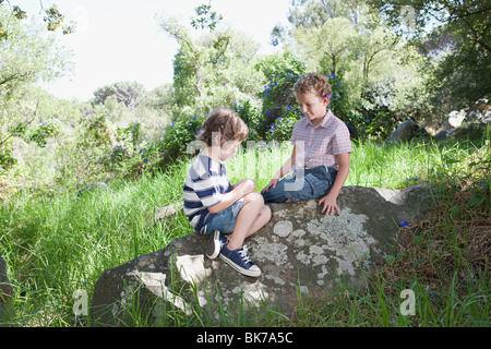 Two boys sitting on a rock Stock Photo