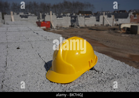 hard hat sitting on a pile of breeze concrete building blocks on construction building site in northern ireland uk Stock Photo
