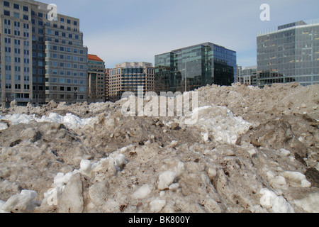Washington DC,10th Street NW,dirty,grimy,snow,plowed,ice,thawing,melting,wet,pollution,winter,cold,weather,parking lot,office buildings,city skyline,p Stock Photo
