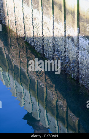 Hull of wood boat reflected in water Stock Photo