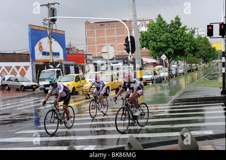Three cyclists in the rain. Medellin, Colombia Stock Photo