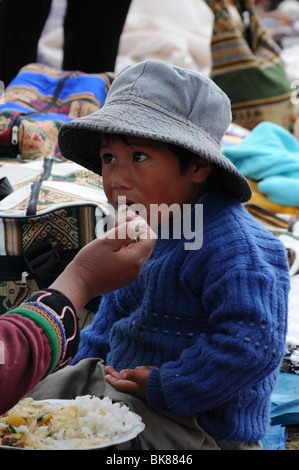 Child being fed at a market, Chinchero, Inca settlement, Quechua settlement, Peru, South America, Latin America Stock Photo